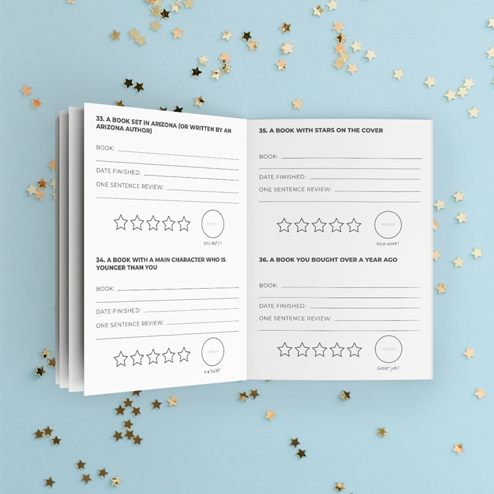 An open sneak peek of some of the challenges inside this year's Reading Challenge booklet including printed review prompts and star rating circles, photographed on a light blue background with scattered gold star confetti. 