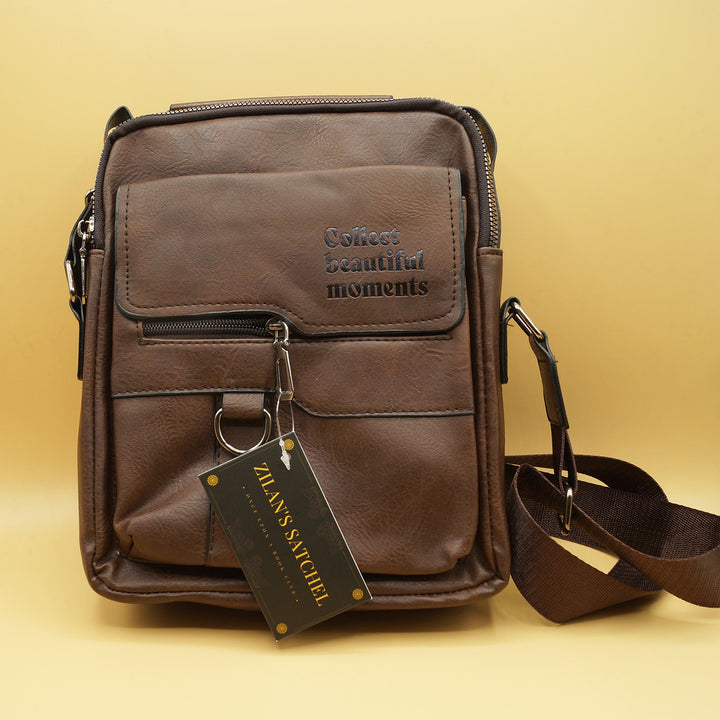 a brown satchel with the quote "Collect Beautiful Moments" printed on the front sits against a yellow background