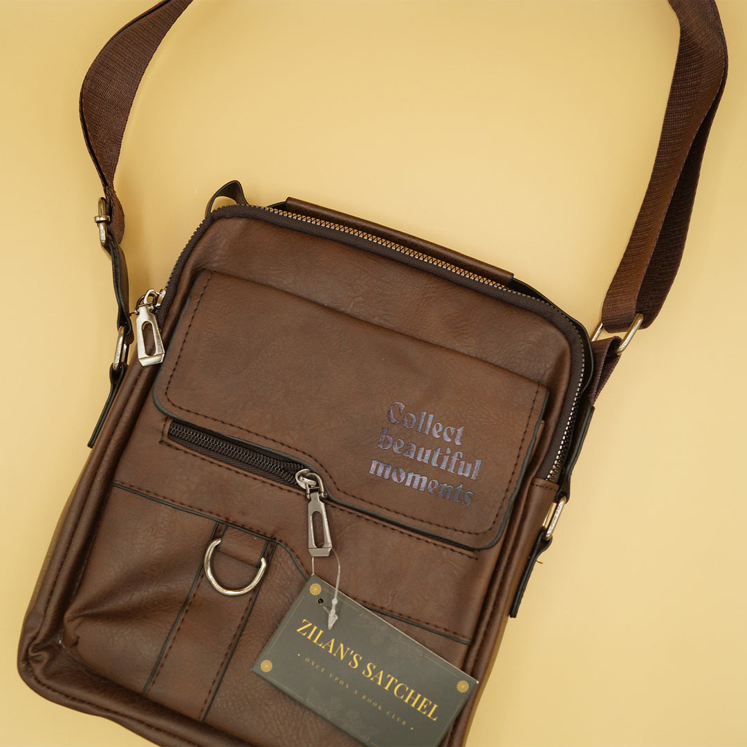 a brown satchel with the quote "Collect Beautiful Moments" printed on the front sits against a yellow background