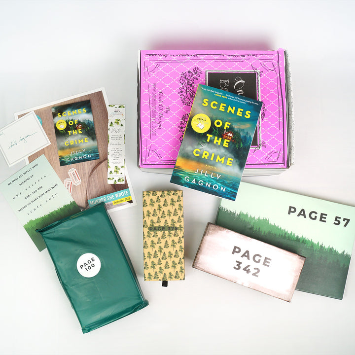 a paperback copy of Scenes of the Crime sits on a pink box. In front of the box, from left to right, are a signature card, bookclub kit, quote card, bookmark, green polybag, and three rectangular boxes. The boxes and bags all have page numbers.