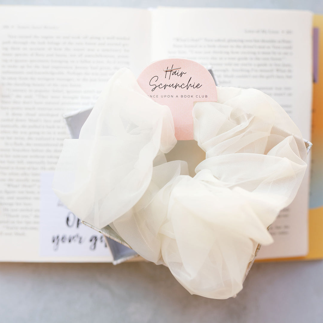 a white tulle scrunchie on an open book 