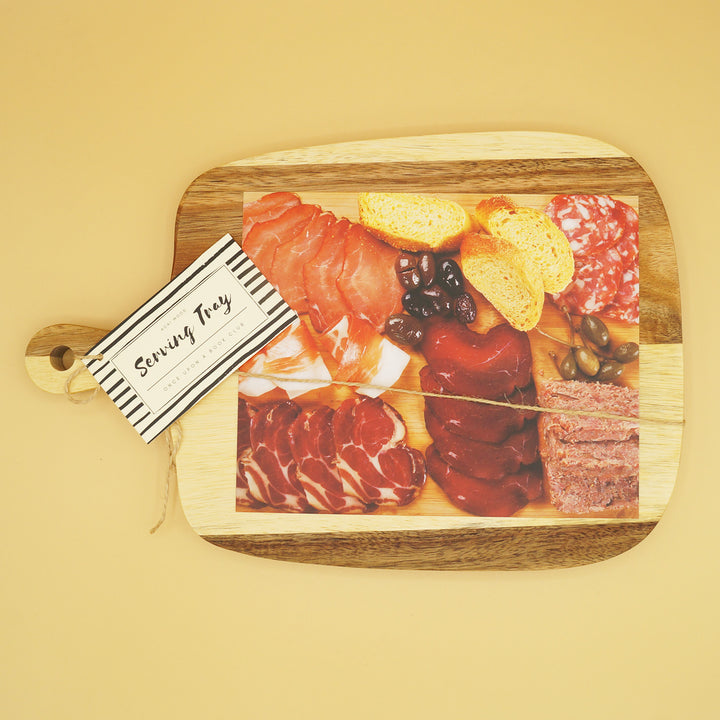 a wooden serving board sits on a yellow background with an image of assorted meats and cheeses on it