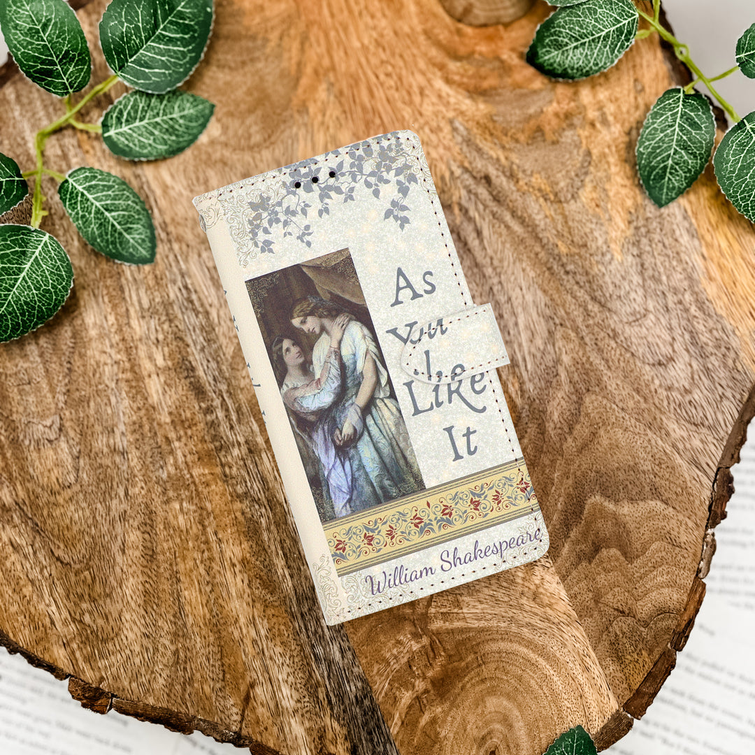Book shaped phone case featuring 'As You Like It" by William Shakespeare on a wooden surface with leaves