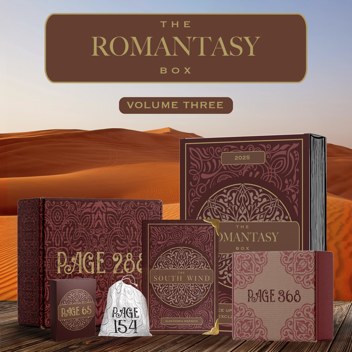 The Romantasy Box Volume 3 featuring The South Wind by Alexandria Warwick featuring red and gold details. Surrounding by red and gold packaging. All components stand in front of a desert background.