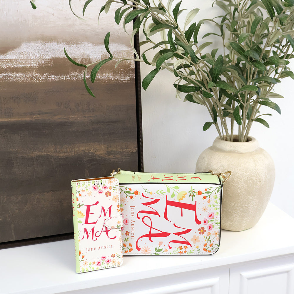 Emma phone case and matching purse on a fireplace mantle with a plant and painting surrounding them.