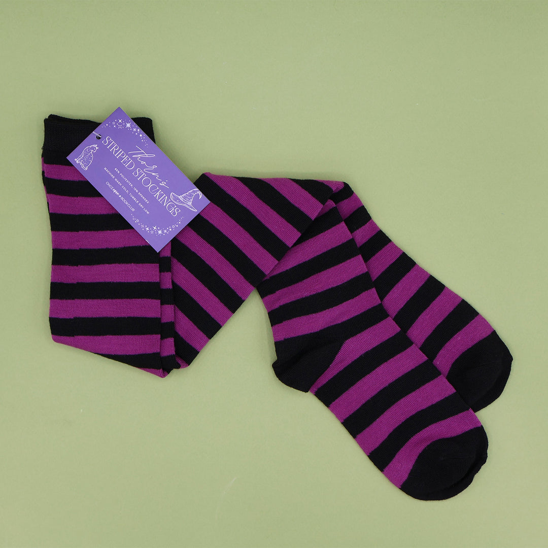A pair of purple and black striped stockings against a light green background.