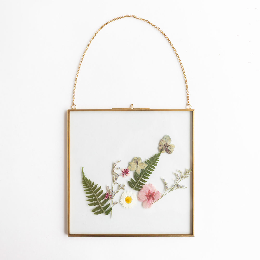 A gold hanging frame with leaves and flowers featured inside.