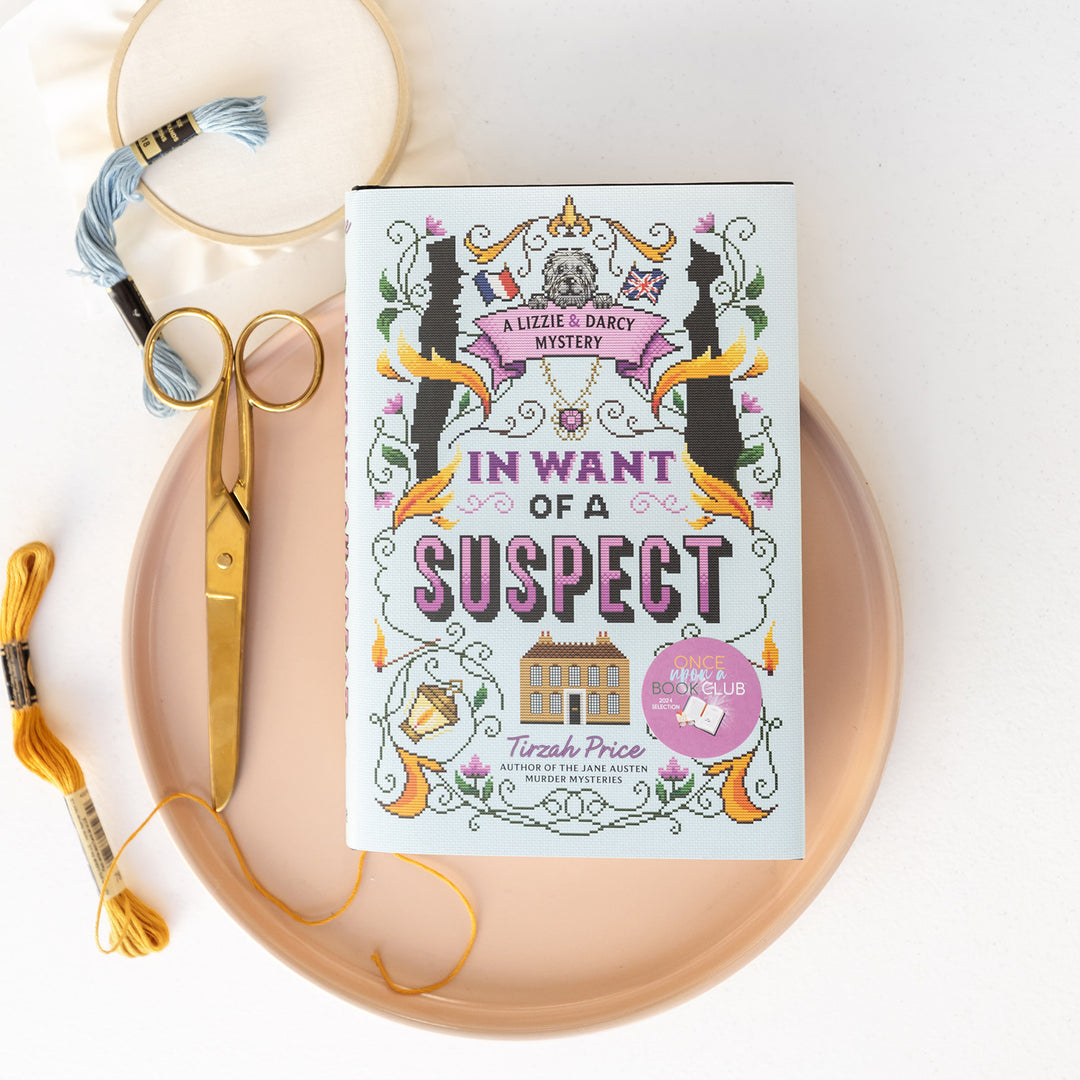 Book titled 'In Want of a Suspect' by Tirzah Price on a decorative plate with embroidery tools.