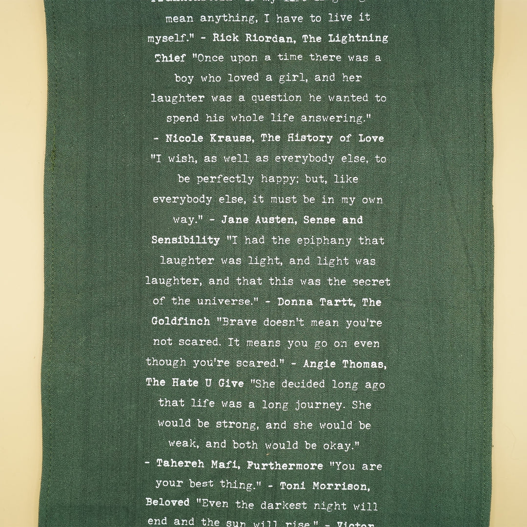 dark green table runner with quotes from books in white writing down the center