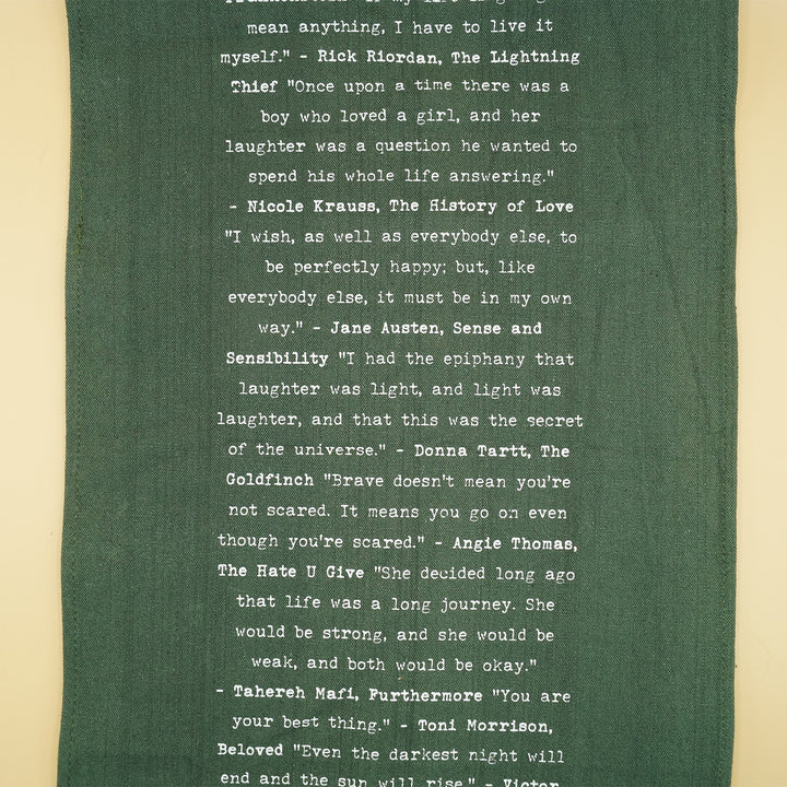 dark green table runner with quotes from books in white writing down the center