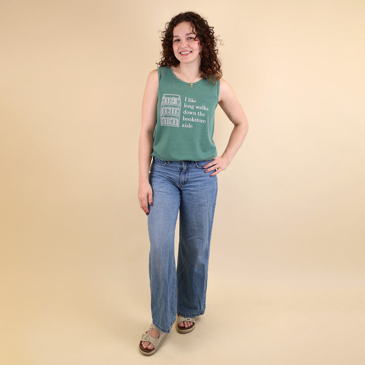 Woman wearing a green tank top with text that reads 'I like long walks down the bookstore aisle' and bookshelf graphic on a beige background.