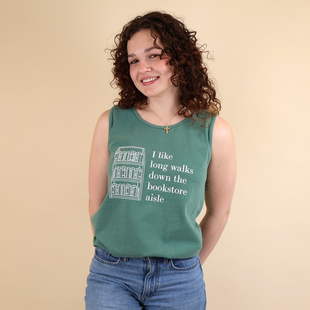 Woman wearing a green tank top with text that reads 'I like long walks down the bookstore aisle' and bookshelf graphic on a beige background.