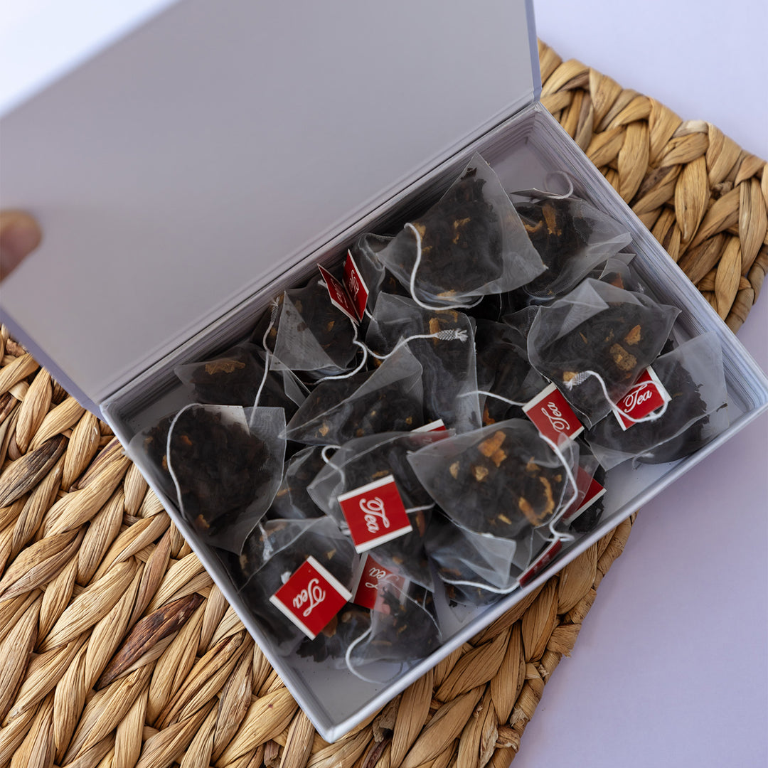 An open light purple box with 20 transparent bags of dark tea