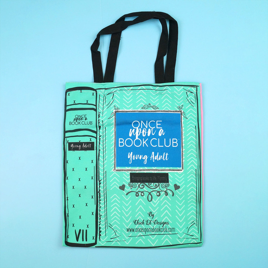 Teal tote bag with "Once Upon a Book Club Young Adult" design, featuring a book spine illustration.
