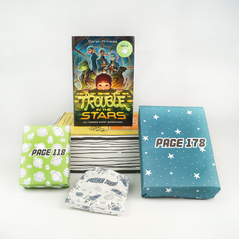 a hardcover edition of Trouble in the Stars sits on a yellow box. In front of the box are a green box with spaceships on it, a white drawstring bag with spaceships on it, and a blue box with stars on it. The boxes and bags all have page numbers.
