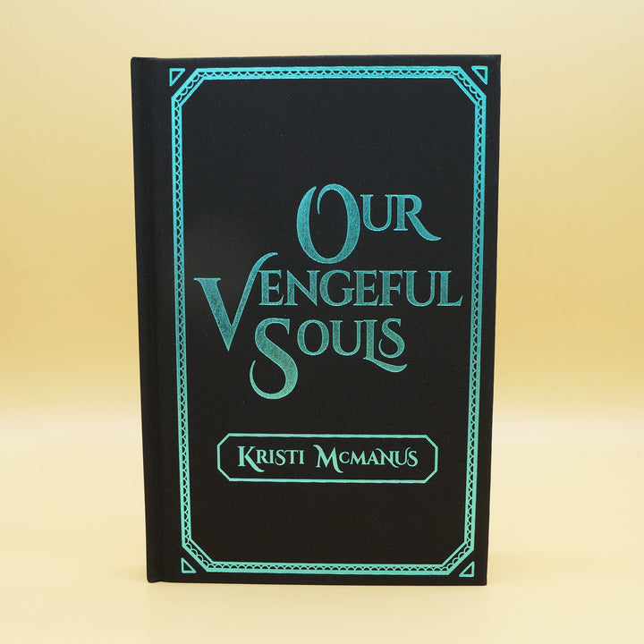 the front hardcase of a hardcover special edition of Our Vengeful Souls. Cover is black with teal writing and teal outline around edge of book