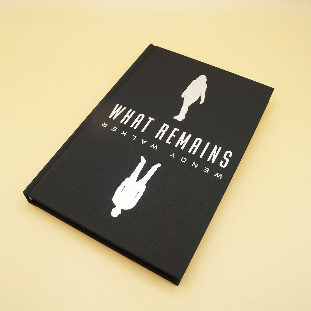 the front hardcase of a hardcover copy of What Remains. the title and author's name are in white with a silhouette of a woman and a man on the cover.