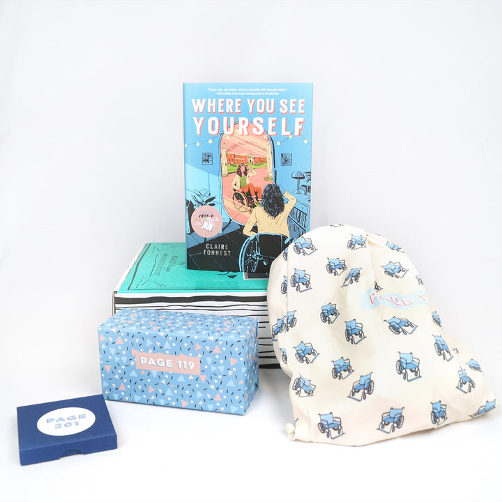 A hardcover edition of Where You See Yourself stands on a green box. In front are a blue square box, a light blue rectangular box, and a white drawstring bag. The boxes and bags all have page numbers.