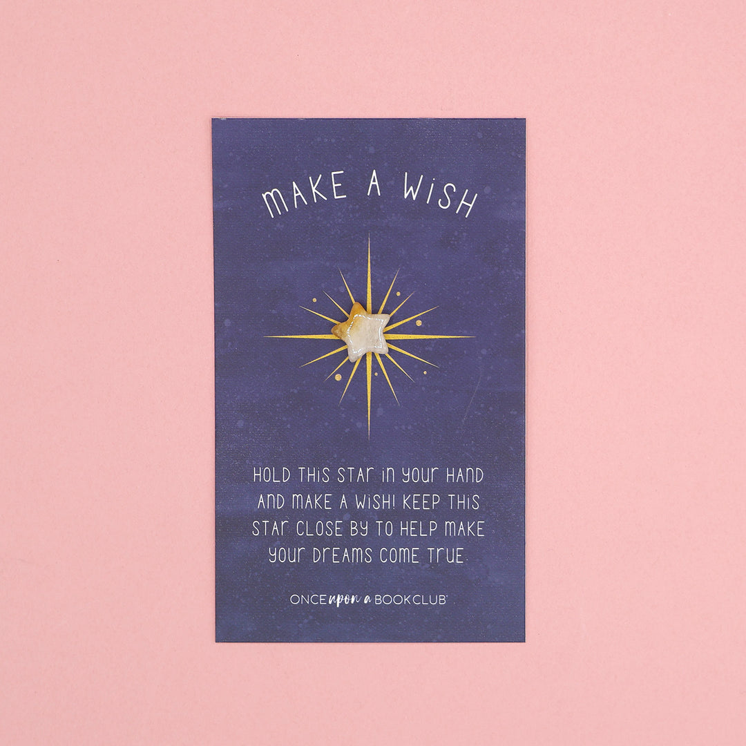 A small white star on a backing card that says 'Make a Wish! Hold this star in your hand and make a wish! Keep this star close by to help make your dreams come true.'