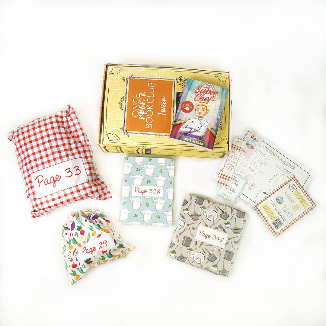 A copy of "The Last Super Chef" by Chris Negron on a yellow OUABC box surrounded by wrapped gifts and paper items.