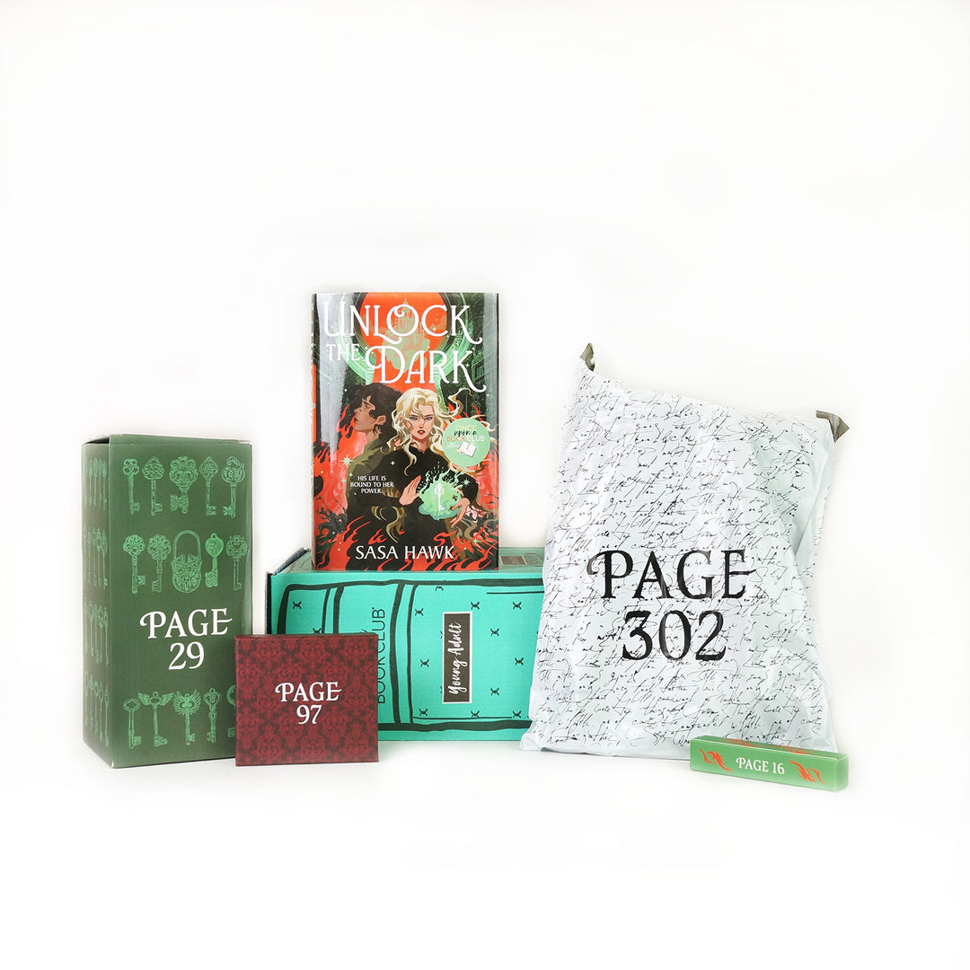 A hardcover copy of Unlock the Dark by Sasa Hawk on a green young adult OUABC box surrounded by wrapped gifts.