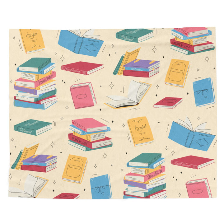 A blanket featuring colorful books on a creamy butter yellow background. The blanket is spread on a white background.
