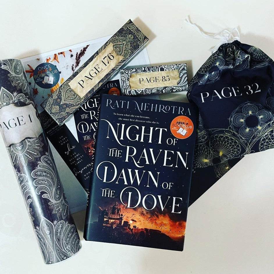 a hardcover edition of Night of the Raven, Dawn of the Dove. Behind it are a collection of wrapped gifts and paper items. The gifts are all labeled with page numbers.