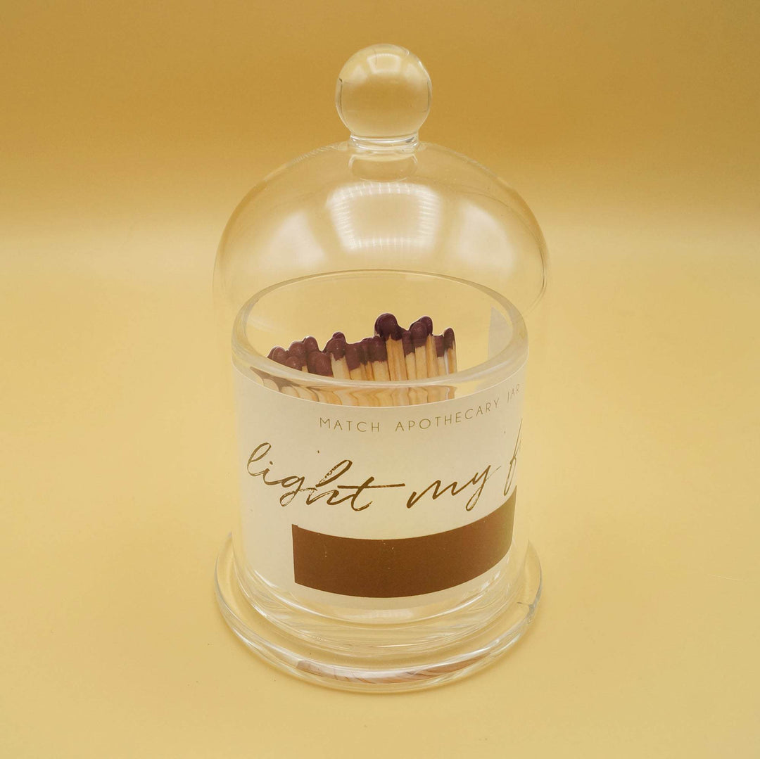 A glass match jar with a printed picture of matches inside it