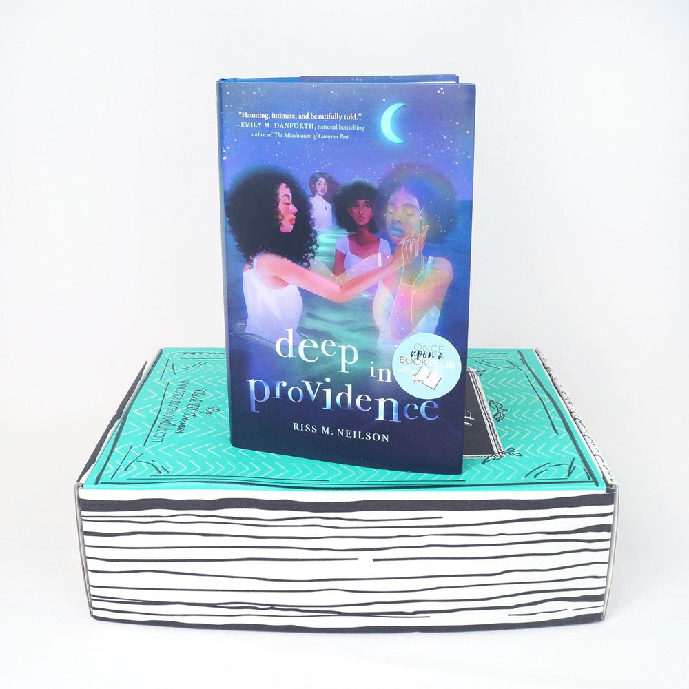 A hardcover edition of Deep in Providence by Riss M Neilson stands on a green Once Upon a Book Club box
