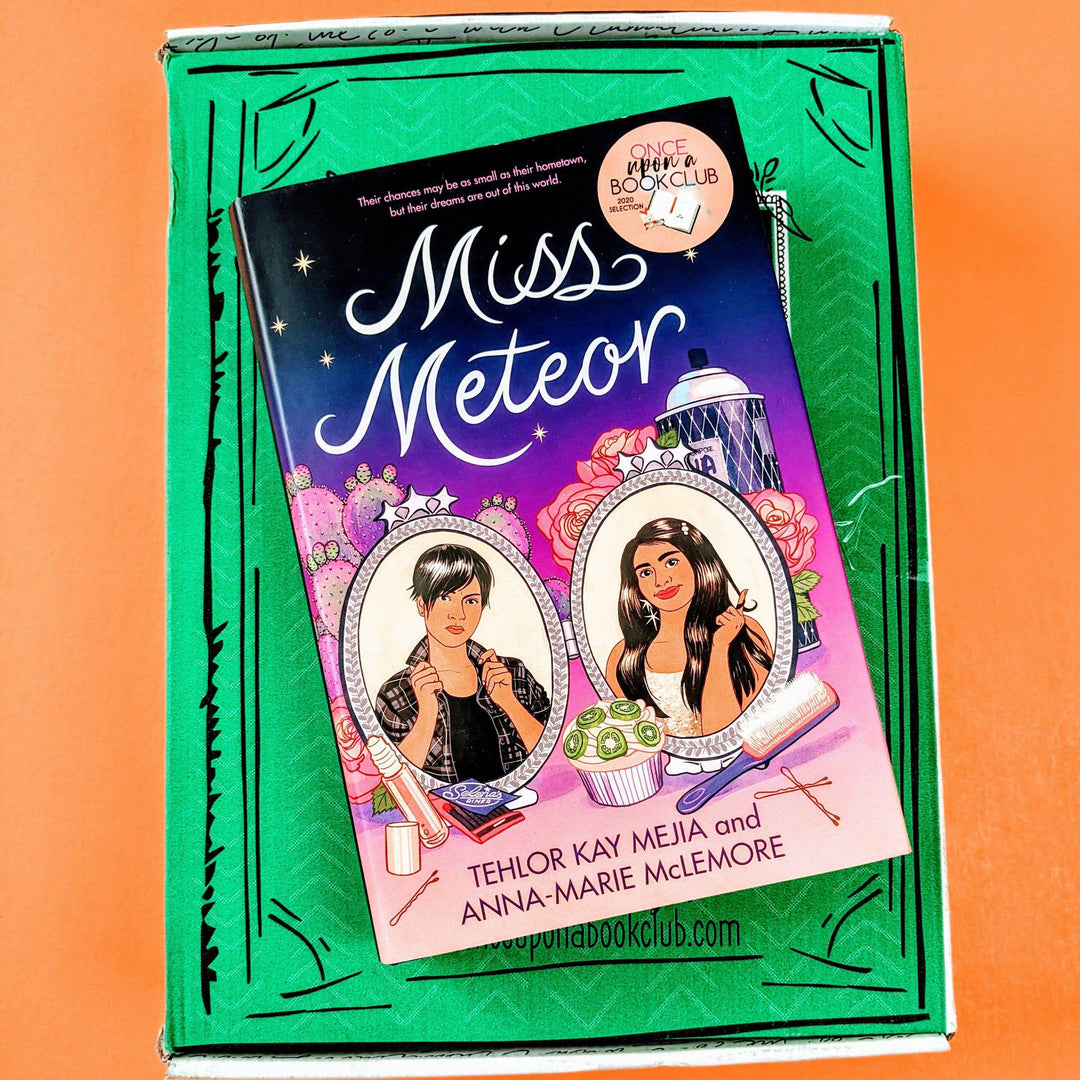 A hardcover edition of Miss Meteor is on a green Once Upon a Book Club box