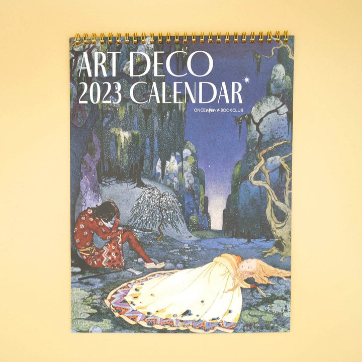 the front of an art deco 2023 wall calendar showing a painting of a woman lying on the ground and a man sitting and leaning against a tree in the forest at night