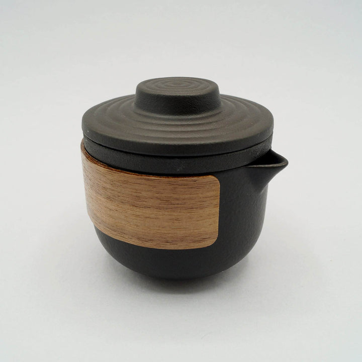 A black ceramic and wood tea pot