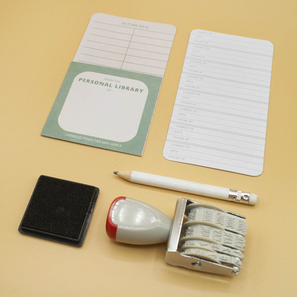 A personal library kit with library cards, a date stamp, ink pad, and pencil