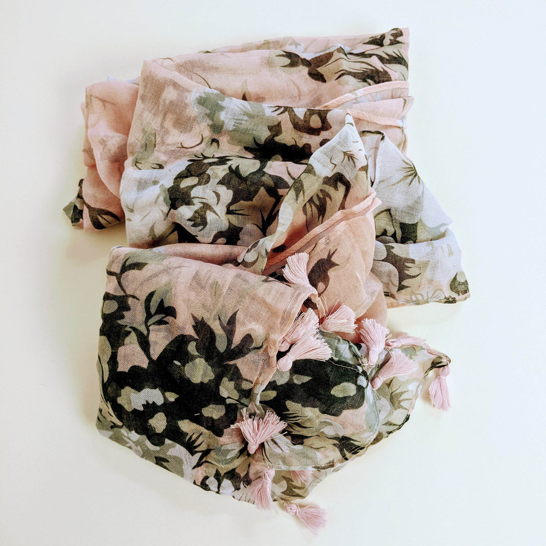 a pastel pink scarf with black flowers is bunched up in the center of the image
