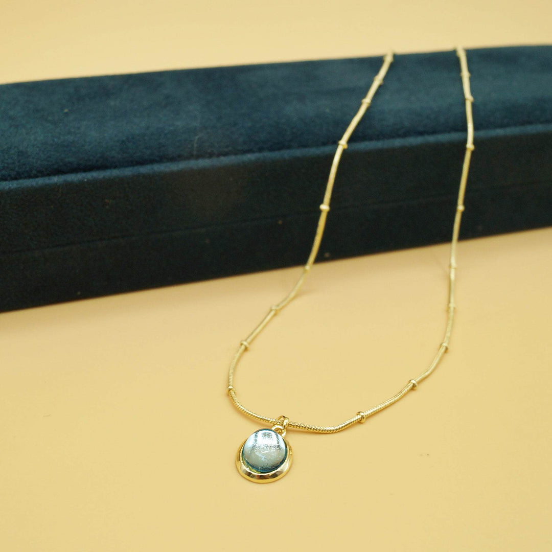 a teal pendant necklace with gold chain