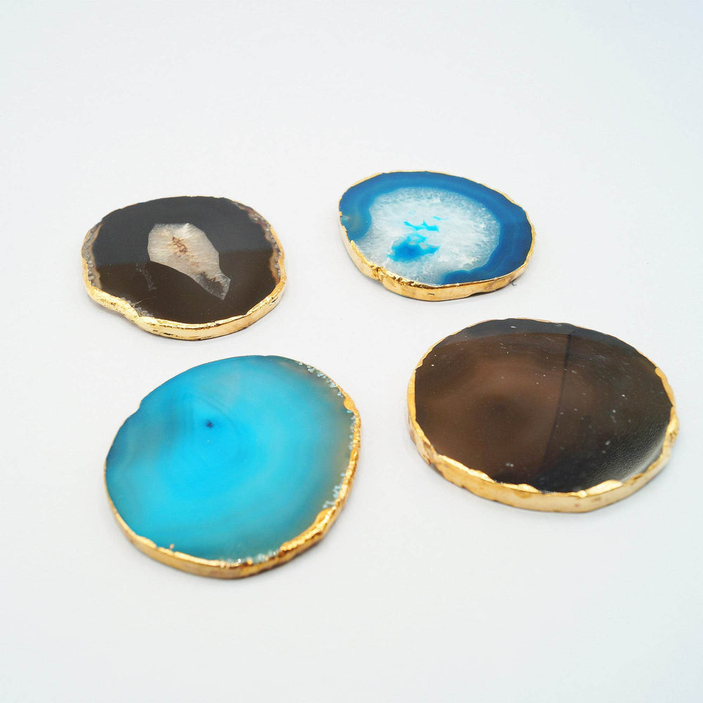 a set of four blue, brown, and black agate geode coasters lined with gold