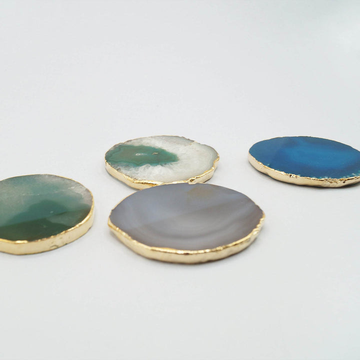 a set of four blue, green, and gray agate geode coasters lined with gold
