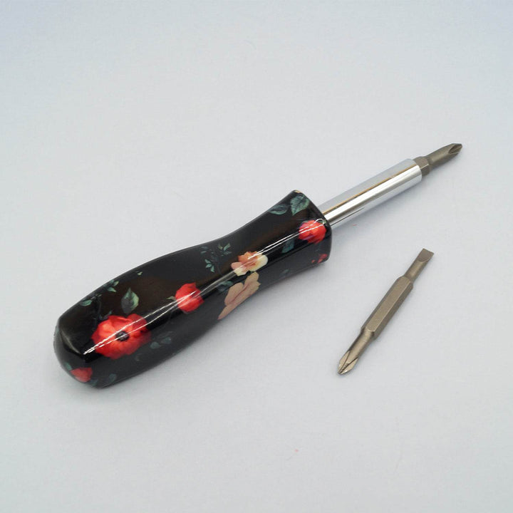 a screwdriver with a black handle with red flowers 