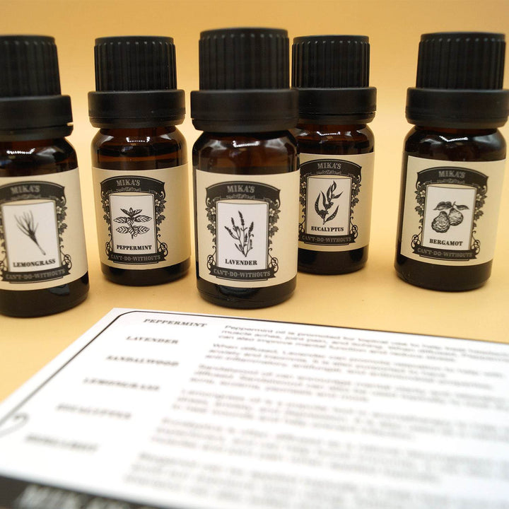 a set of five essential oils stand in a line in front of a white information card