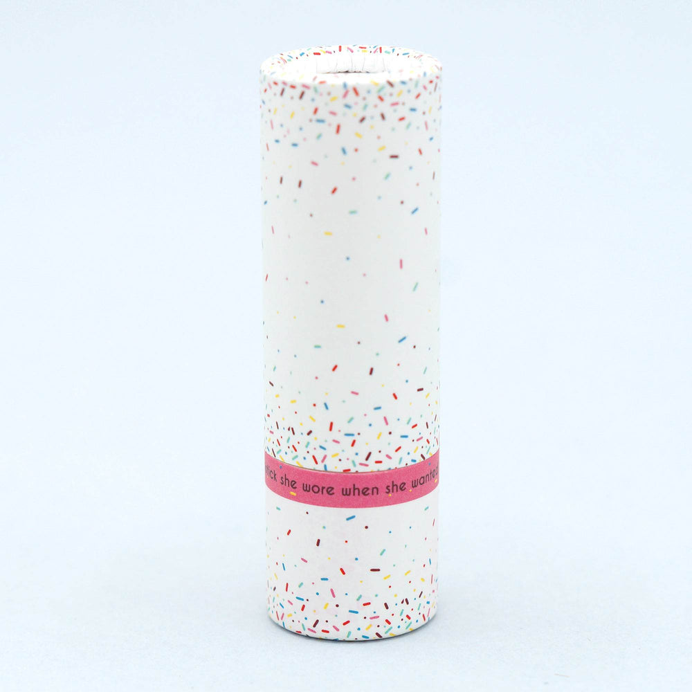a white lipstick tube with multicolored sprinkles pattern