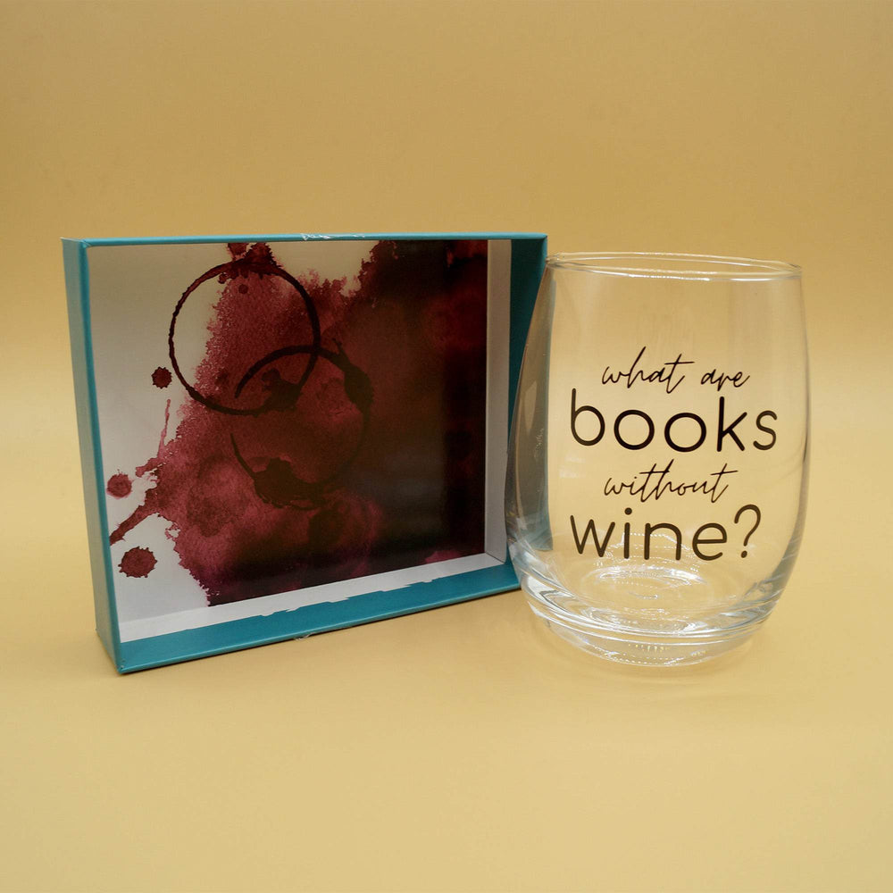 A stemless wine glass with the quote "What are books without wine?" in black letters sits next to a box lid. The underside of the box lid is showing a fake red wine stain