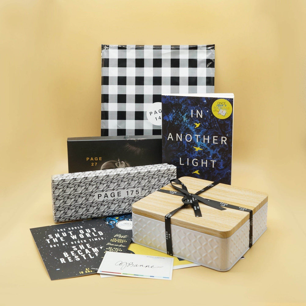 A paperback edition of In Another Light is in front of a black and white checkered bag. Next to the book are a black rectangular box, white and black rectangular box, box with wooden lid, and an assortment of paper items. The boxes and bags all have page numbers.
