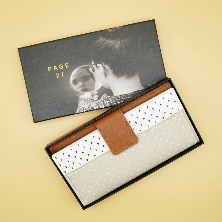 a brown wallet with polka dots is in a box