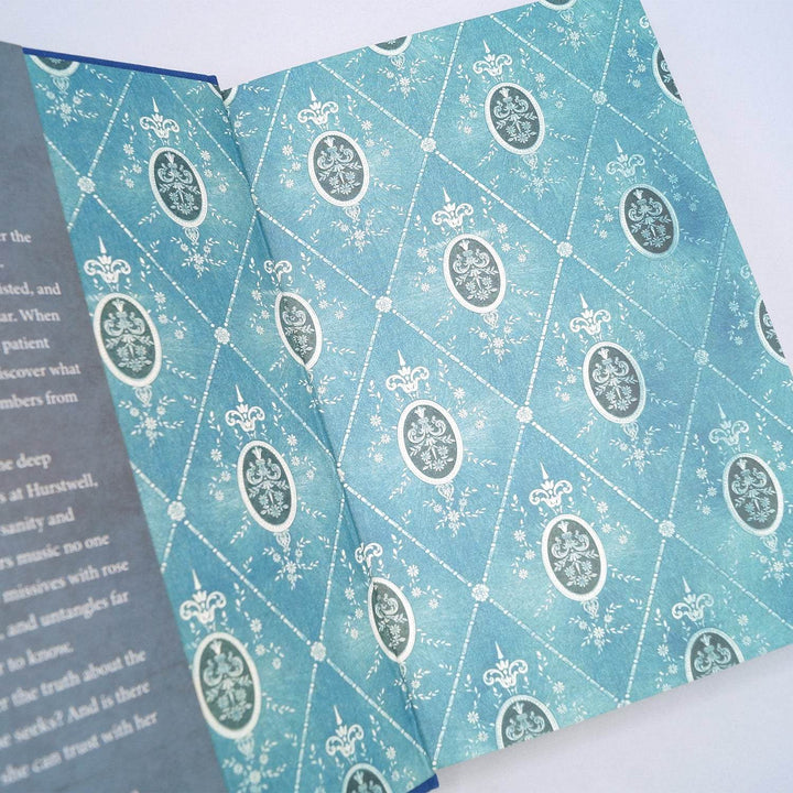 the inside end papers of a hardcover special edition of The Lost Melody. End papers show a teal and white pattern 