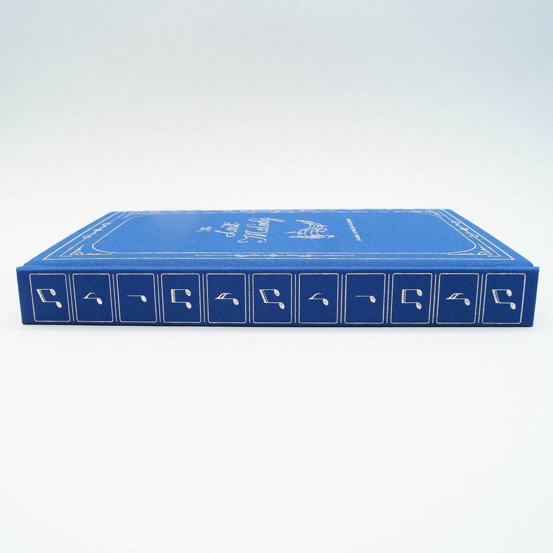 the spine of a hardcover special edition of The Lost Melody. The book is blue and silver music notes on the spine