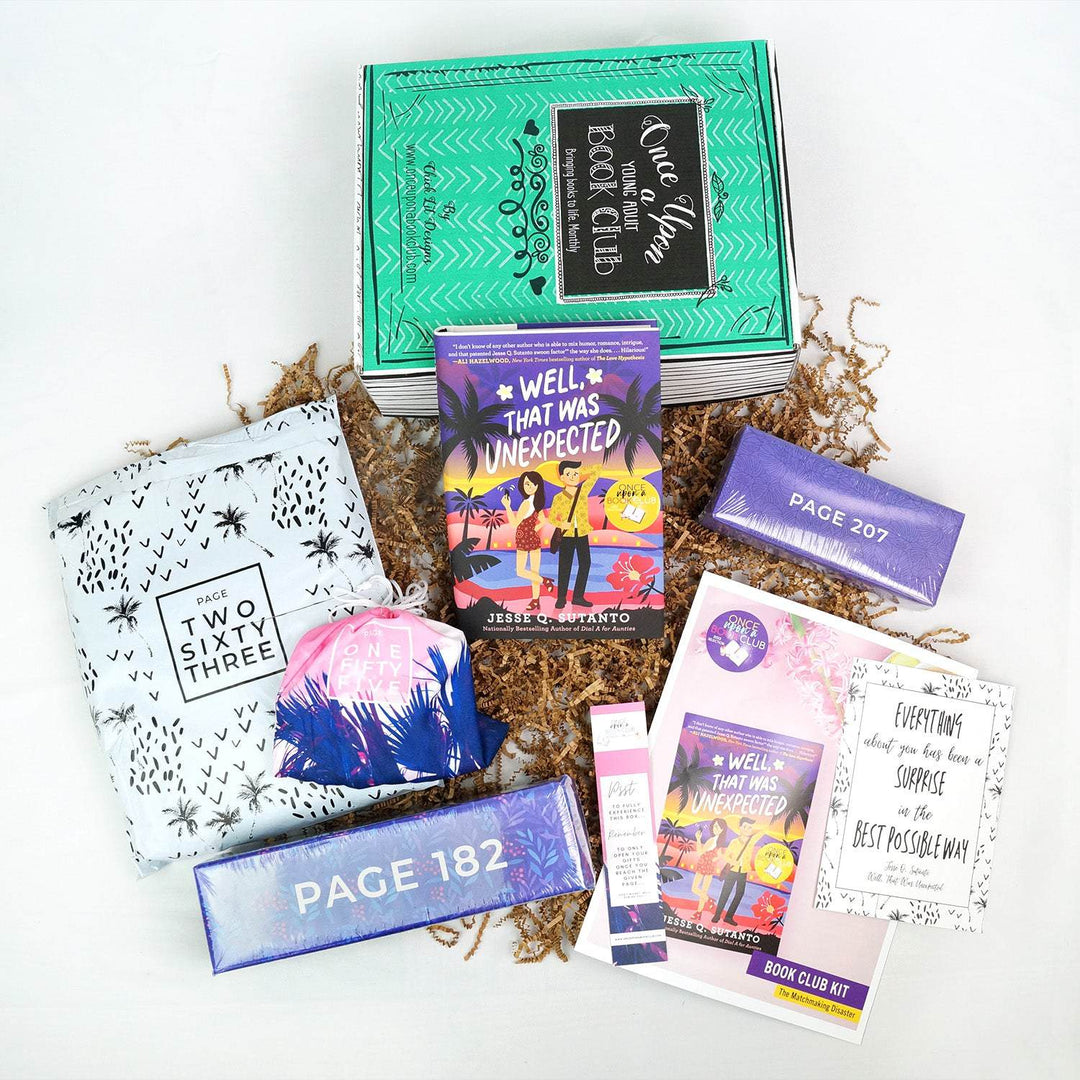 A hardcover edition of Well, That Was Unexpected leans against a green Once Upon a Book Club box. In front are a white bag, two purple boxes, a pink drawstring bag, bookmark, bookclub kit, and quote card.  All bags and boxes are labeled with page numbers.