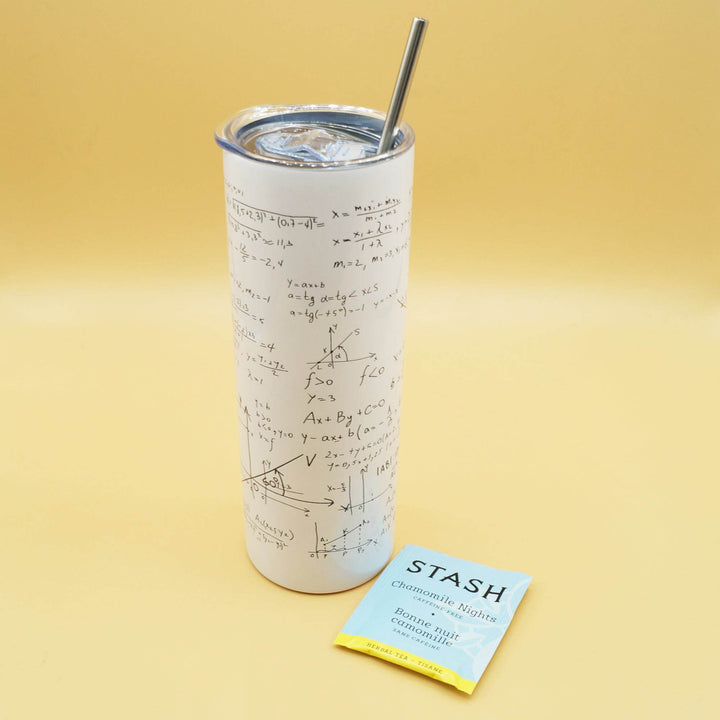 a white tumbler with black equations across it and a metal straw coming out of the top is next to a packet of Stash tea